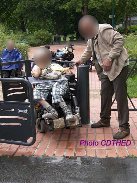 La personne qui aide est obligée de se tenir à l'extérieur de la chicane pendant que le fauteuil roulant traverse la chicane. Sur la photo, on peut constater la difficulté de la manœuvre.